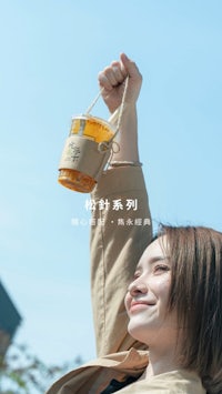 a woman is holding up a cup of honey